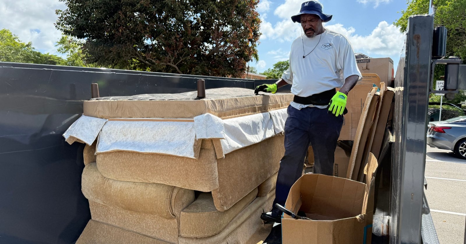 High Caliber Junk Removal team member removing sofa and household items during residential junk cleanout in Broward County Florida