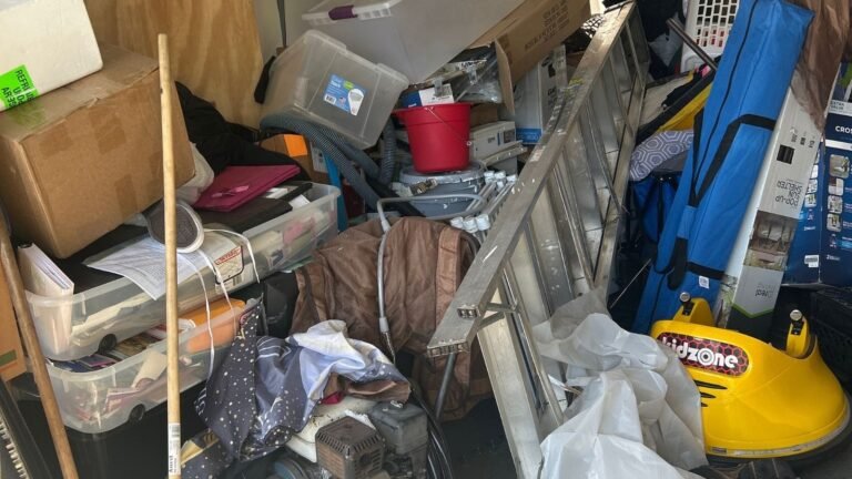 Cluttered garage filled with boxes, household junk, and unwanted items before a garage cleanout