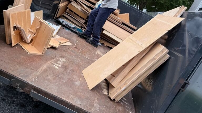 Worker removing lumber and construction debris from a property
